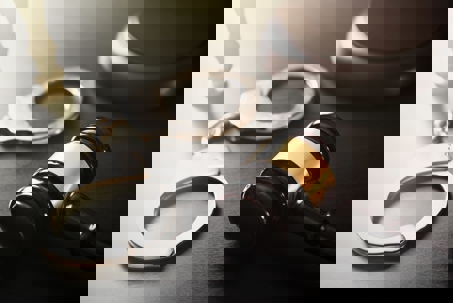 Handcuff and gavel on a desk.